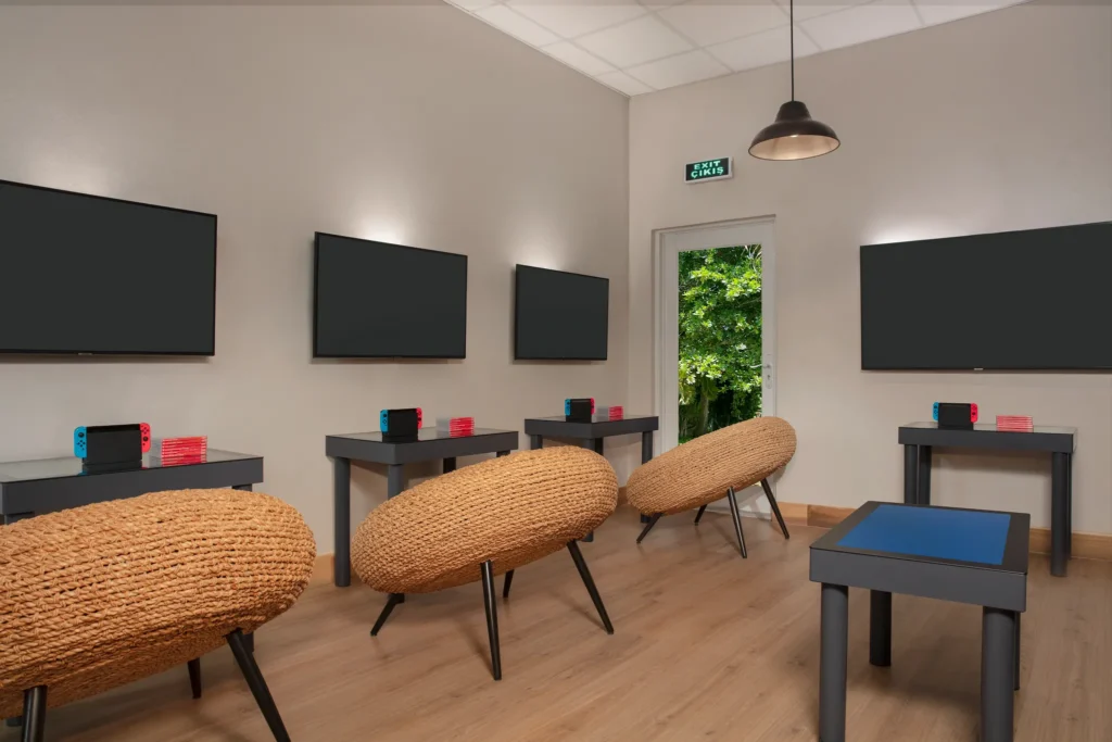 Modern video game room with consoles and screens at Dreams Curaçao Resort, designed for teen entertainment.