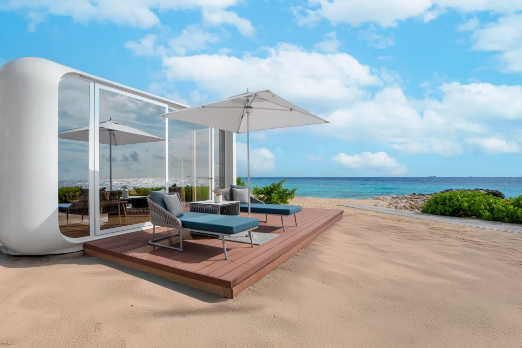 Preferred Club Mare Premium Beachfront Bungalow terrace with chaise lounges and umbrella overlooking the ocean at Dreams Curaçao Resort.