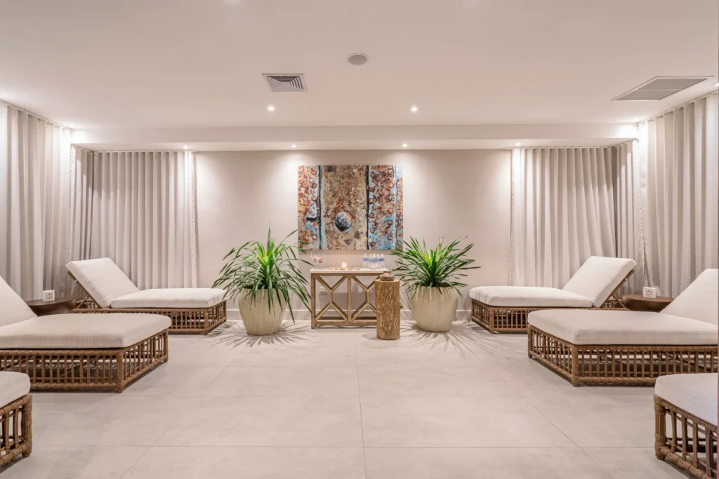 Tranquil spa relaxation lounge with cushioned daybeds and tropical decor at Dreams Curaçao Resort, Spa & Casino.
