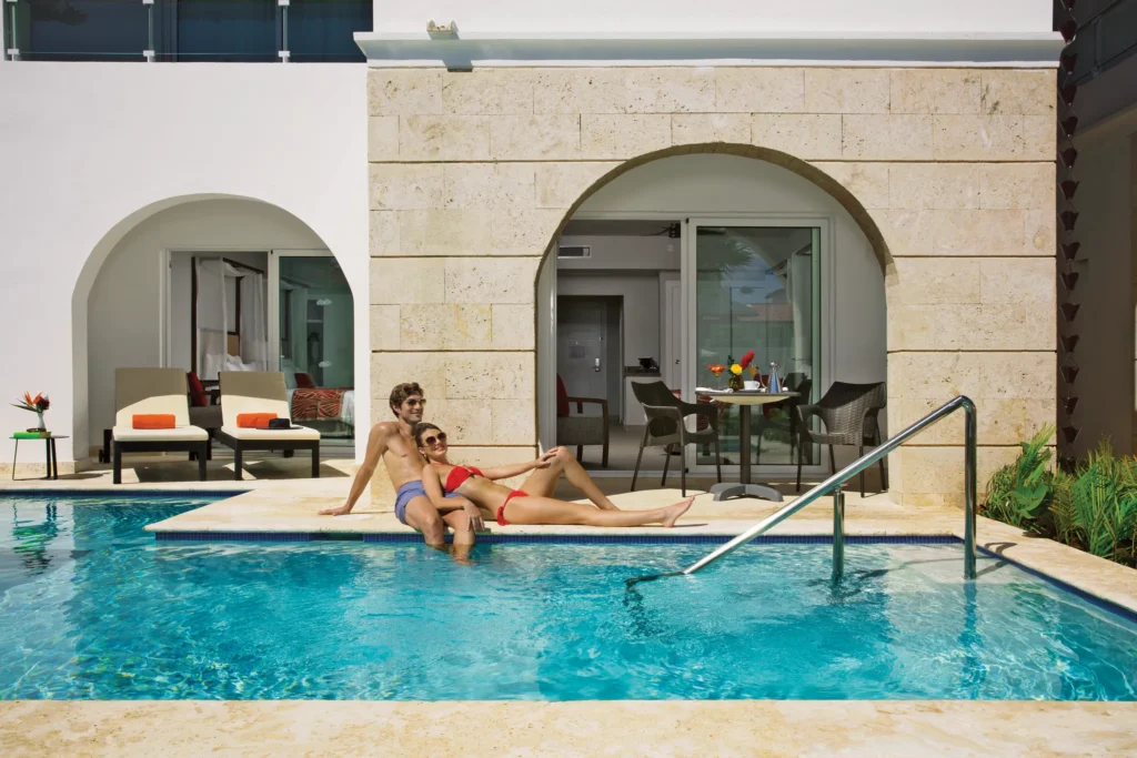 Couple relaxing by the private swim-up plunge pool at Preferred Club Suite Swim-Up at Dreams Dominicus La Romana.