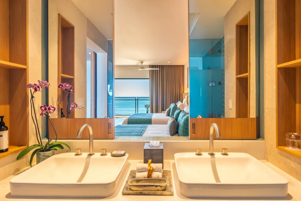 Deluxe Junior Suite Ocean View bathroom with double sinks and large mirror at Dreams Estrella del Mar Mazatlan Resort.
