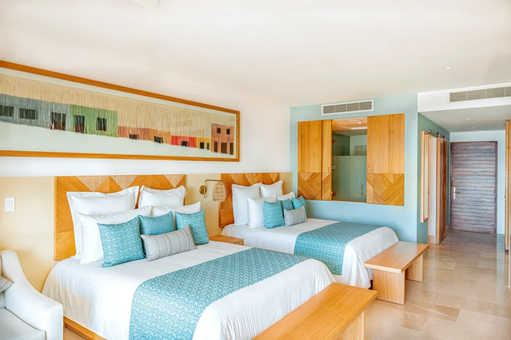 Deluxe Suite Ocean View with two double beds and modern coastal décor at Dreams Estrella del Mar Mazatlan Golf & Spa Resort.