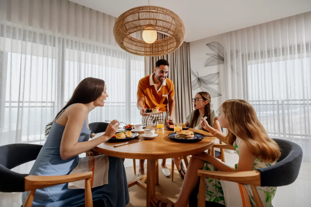 Family enjoying breakfast together in a bright suite dining area at Dreams Estrella del Mar Mazatlan Golf & Spa Resort.