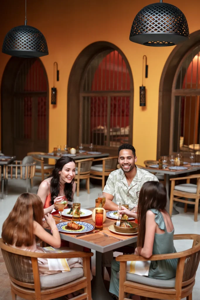 Family enjoying dinner together at a stylish restaurant inside Dreams Estrella del Mar Mazatlan Golf & Spa Resort.