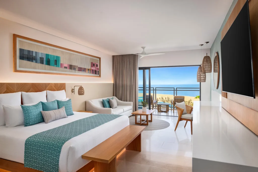 Junior Suite Ocean View with king bed, sofa seating, and oceanfront balcony at Dreams Estrella del Mar Mazatlan.