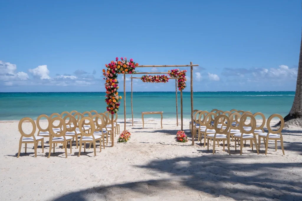 Beach wedding ceremony setup with floral arch and ocean backdrop at Dreams Flora Resort & Spa