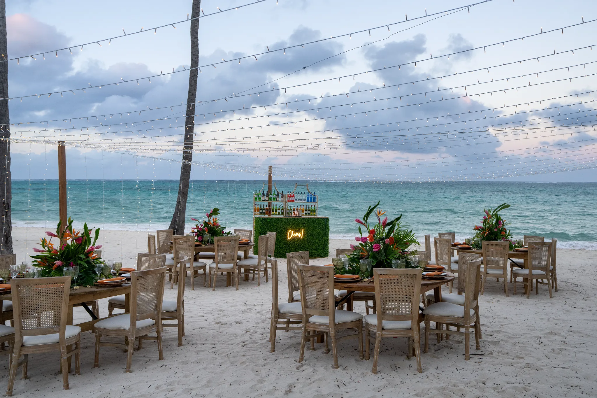 Beach reception setup with string lights and ocean views at Dreams Flora Resort & Spa