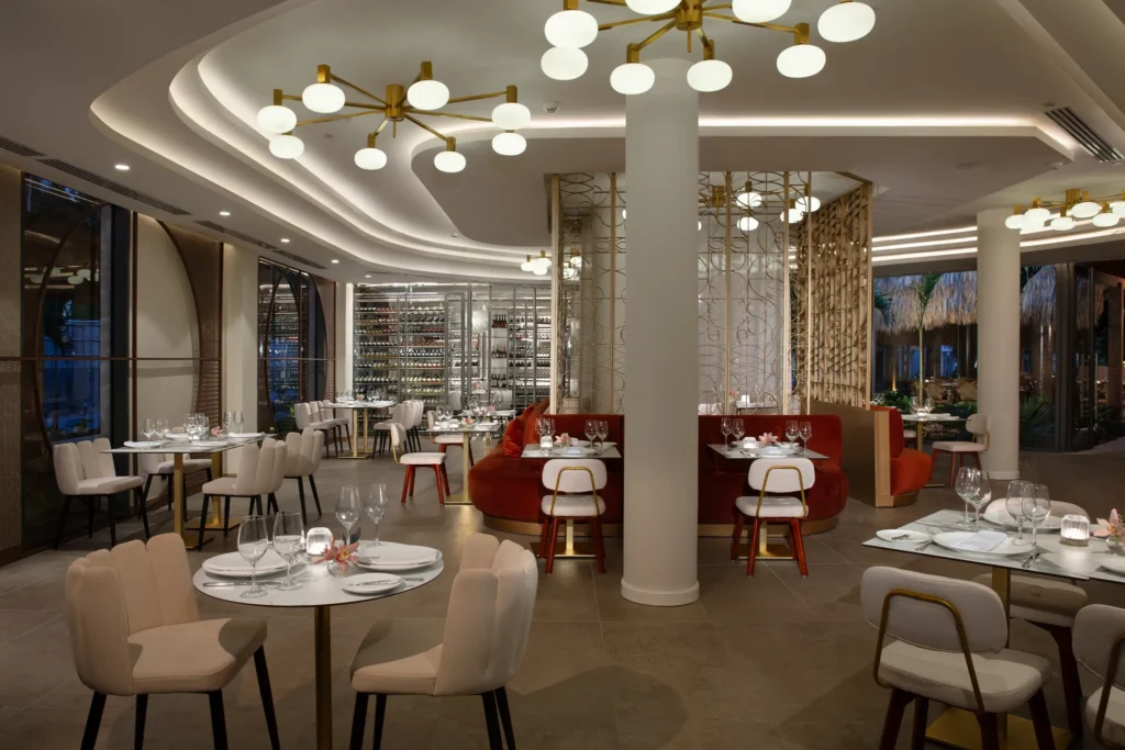 Bordeaux French restaurant at Dreams Flora Resort & Spa featuring elegant dining room, modern décor, wine display, and intimate seating.