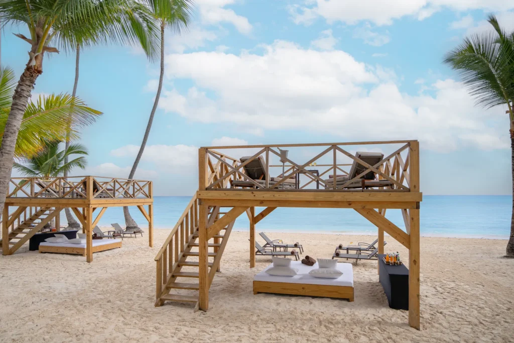 Beach cabanas and bali beds on white sand at Dreams Flora Resort & Spa Punta Cana.