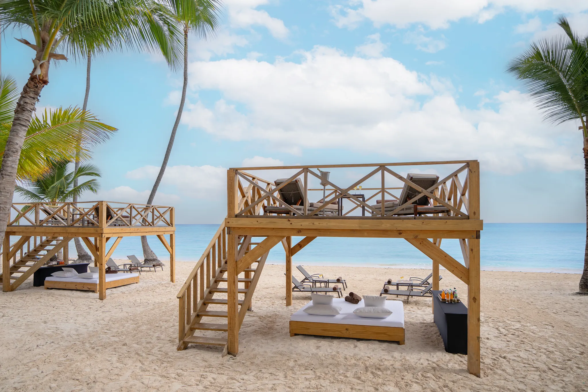 Beach cabanas and bali beds on white sand at Dreams Flora Resort & Spa Punta Cana.