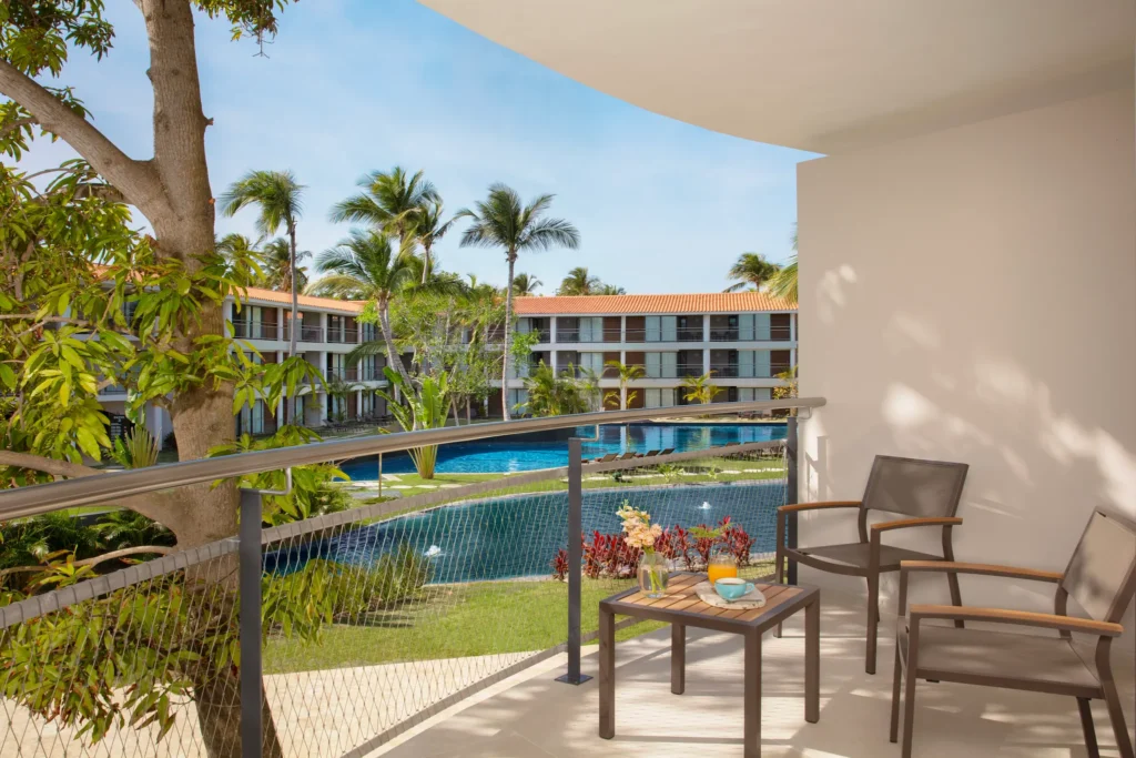 Junior Suite Pool View balcony with seating overlooking resort pool at Dreams Flora Resort & Spa.