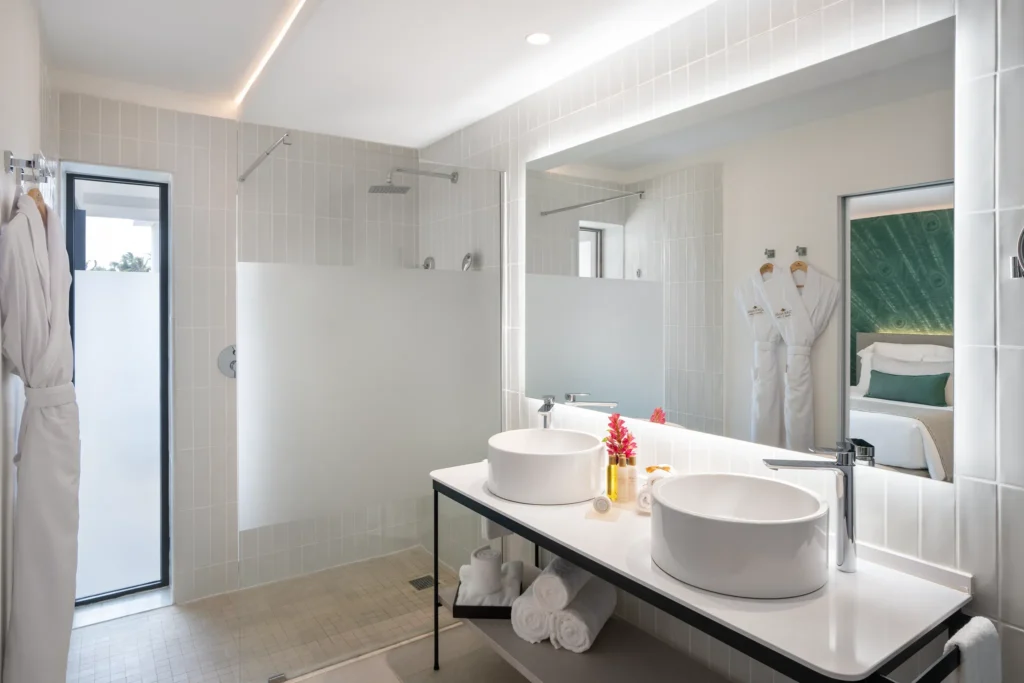 Junior Suite Swim Up bathroom with double sinks and walk-in rain shower at Dreams Flora Resort & Spa.