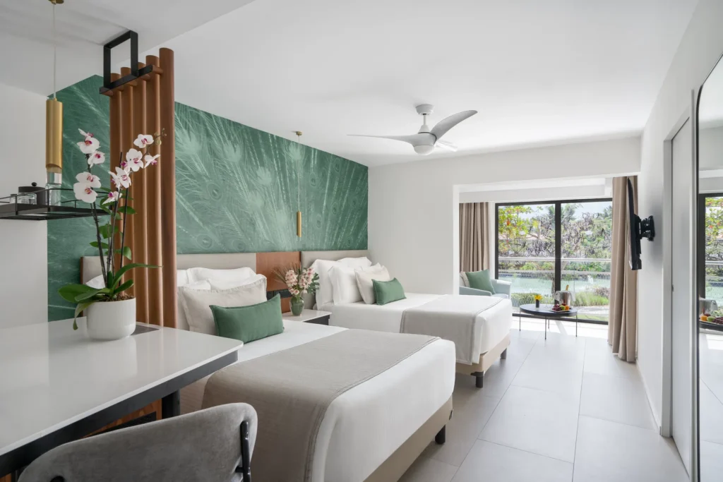 Junior Suite Tropical View with two double beds and garden view balcony at Dreams Flora Resort & Spa.