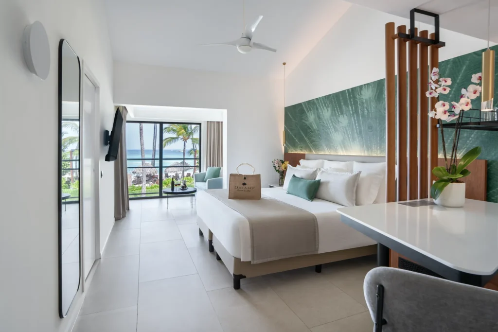Preferred Club Junior Suite Ocean View king bedroom with seating area and ocean view at Dreams Flora Resort & Spa.