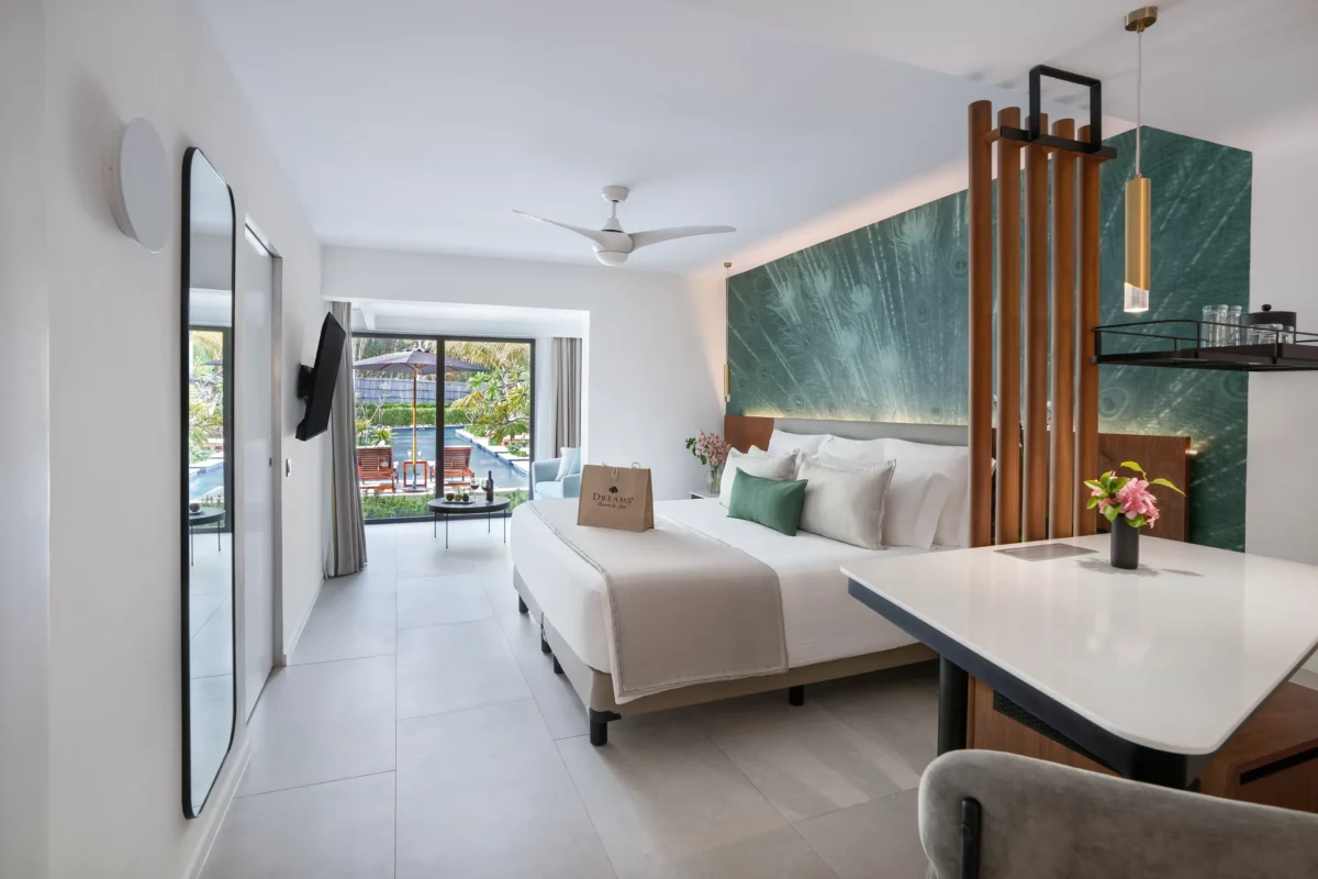 Preferred Club Junior Suite Swim Up king bedroom with modern décor at Dreams Flora Resort & Spa.