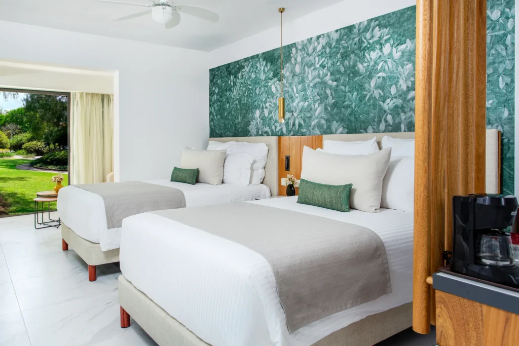 Preferred Club Junior Suite Tropical View with two double beds and garden view at Dreams Flora Resort & Spa.