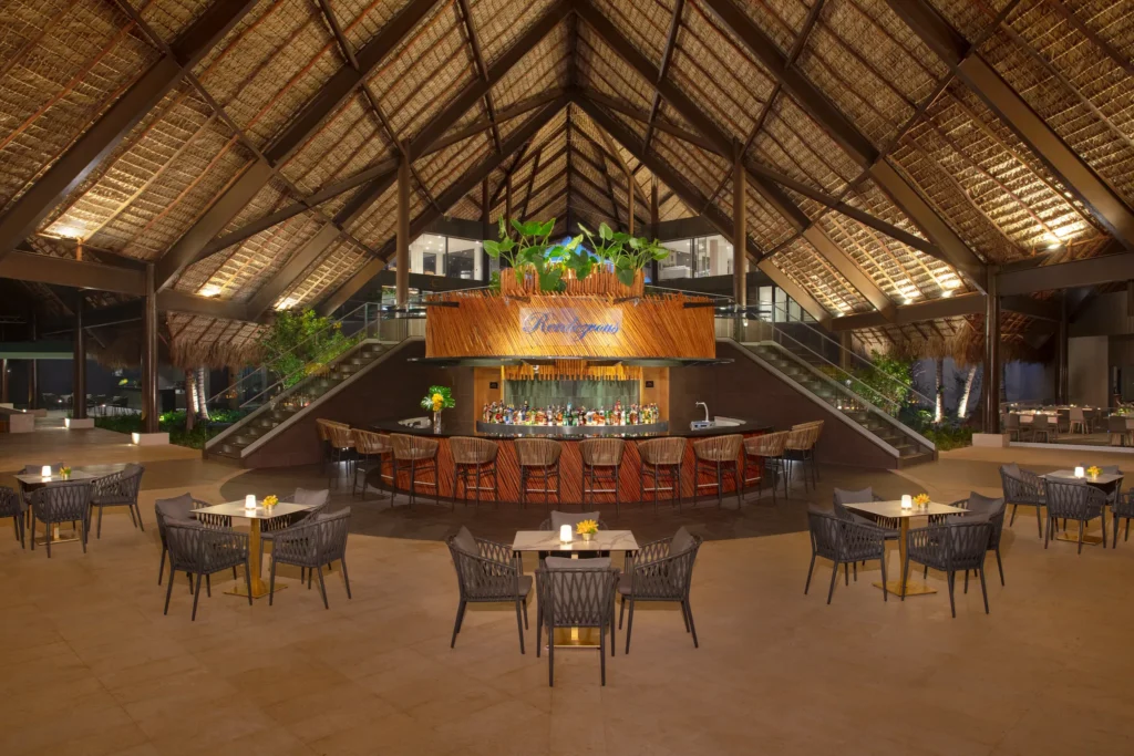 Rendezvous lobby bar at Dreams Flora Resort & Spa featuring a grand open-air design, central bar, and elegant lounge seating.