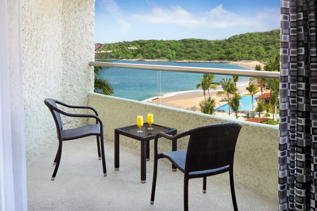 Private furnished balcony with partial ocean view at Deluxe Partial Ocean View room at Dreams Huatulco Resort & Spa.
