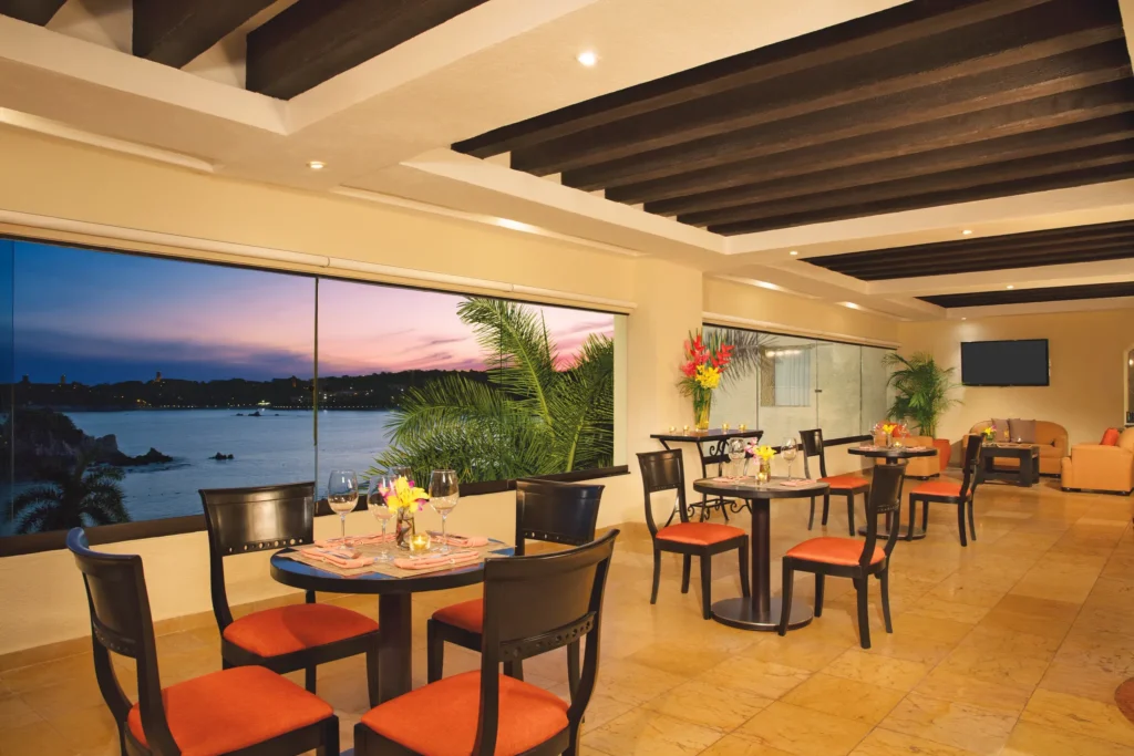 Elegant Preferred Club lounge with ocean views at Dreams Huatulco Resort & Spa during sunset.