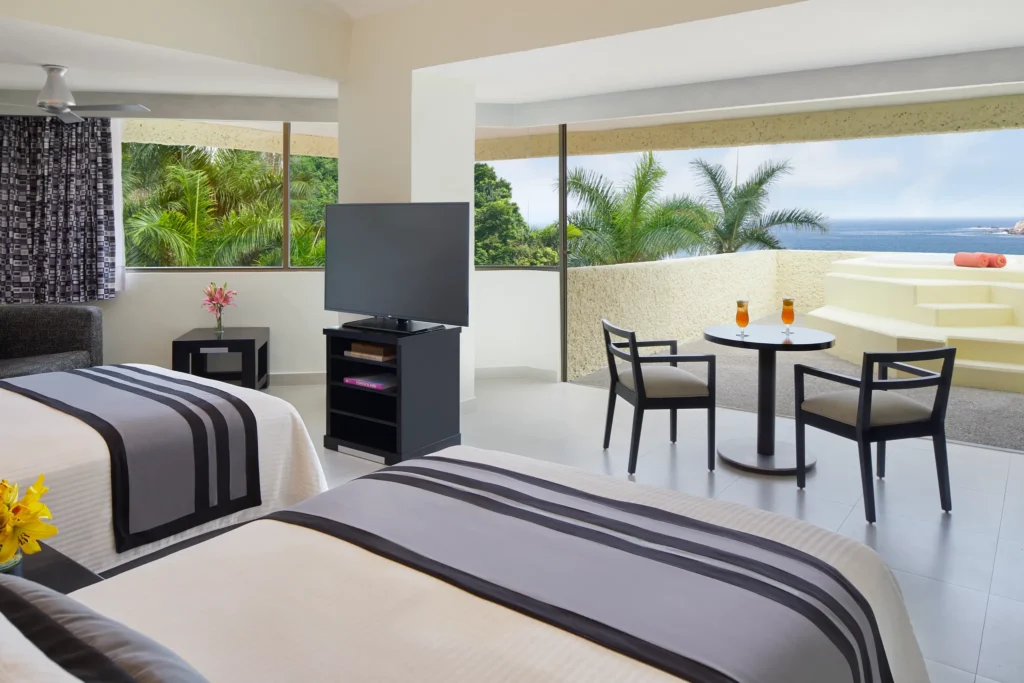 Preferred Club Junior Suite with two double beds and oceanfront views at Dreams Huatulco Resort & Spa.