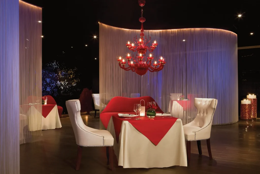 Cin Cin Mediterranean restaurant at Dreams Jade Resort & Spa featuring romantic candlelit tables, red chandelier, and elegant dining décor.