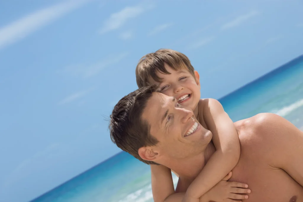 Father and son enjoying quality time on the beach at Dreams Jade Resort & Spa in Puerto Morelos.