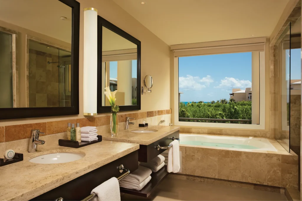 Family Suite Tropical View bathroom with hot tub, dual vanities, and separate rain shower at Dreams Jade Resort & Spa.