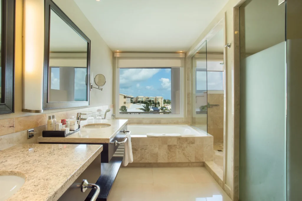 Junior Suite Ocean Front View bathroom with soaking tub and glass-enclosed shower at Dreams Jade Resort & Spa.