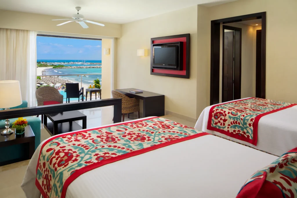 Junior Suite Ocean View with two double beds and private balcony at Dreams Jade Resort & Spa overlooking the Caribbean Sea.