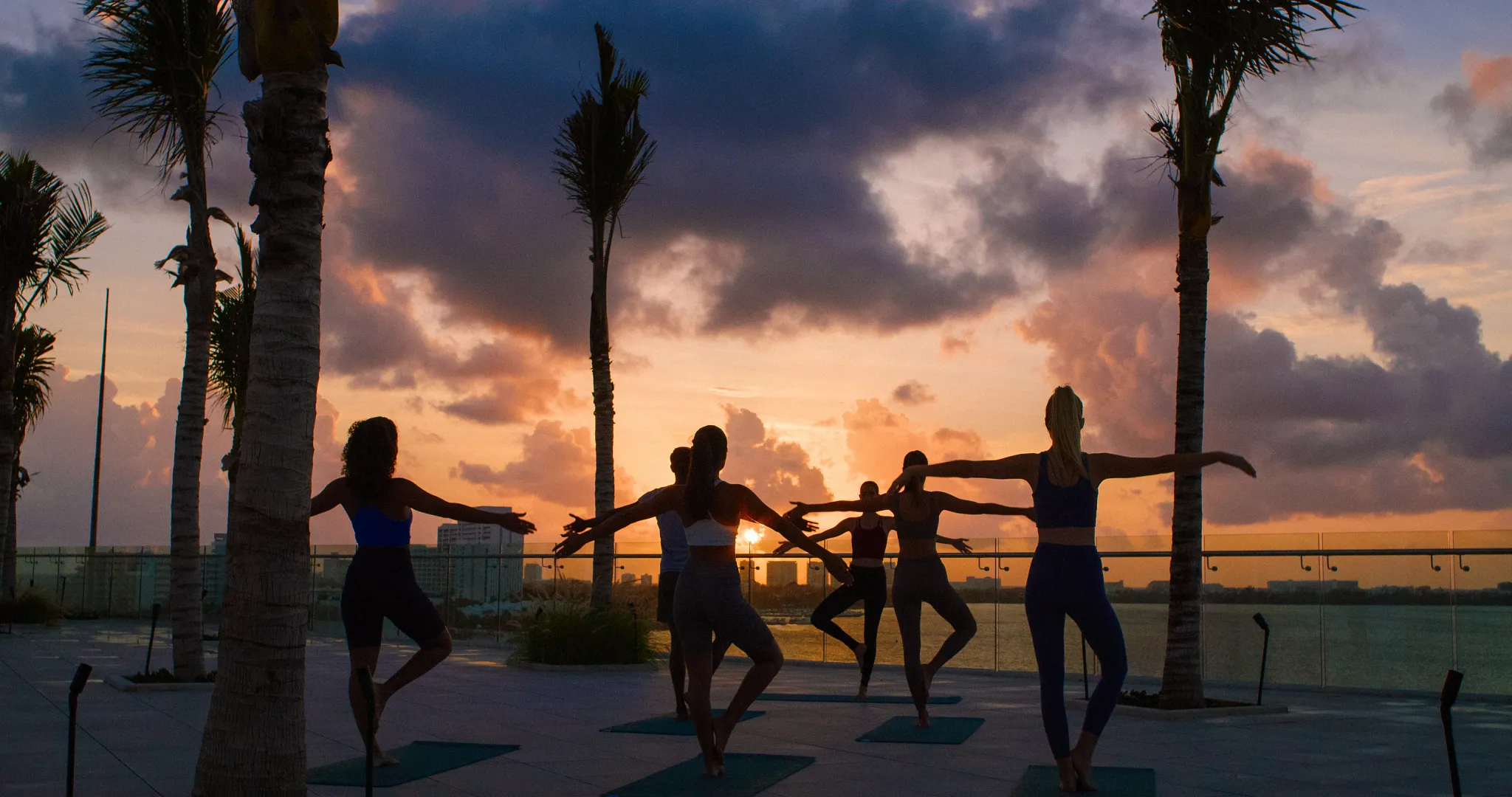 Guests practicing sunrise yoga overlooking the ocean at Breathless Cancun Soul Resort in Cancun.