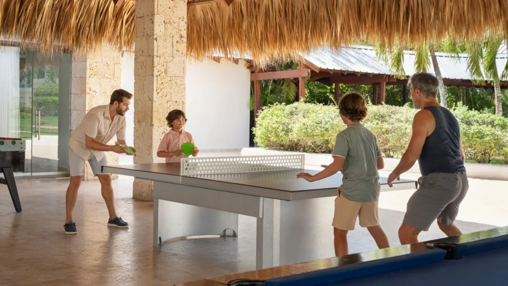 Family enjoying table tennis and games at the teens club area at Dreams La Romana Resort & Spa in the Dominican Republic.