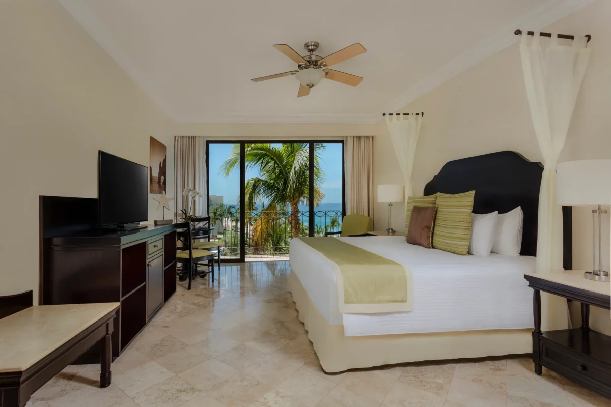 One Bedroom Suite Ocean View bedroom with king bed and private balcony view at Dreams Los Cabos Suites Golf Resort & Spa.