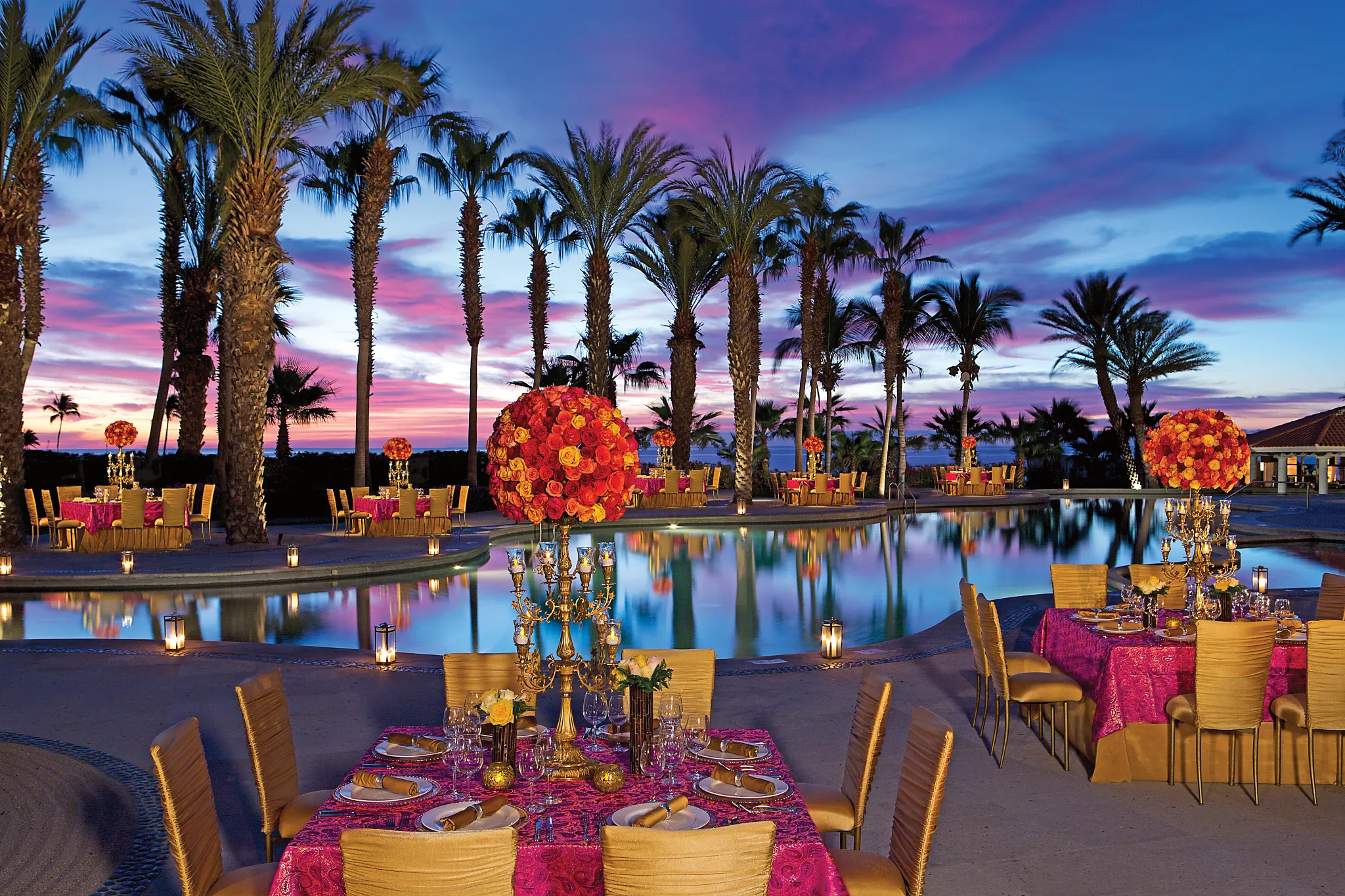 Poolside wedding reception and gala dinner setup at sunset at Dreams Los Cabos