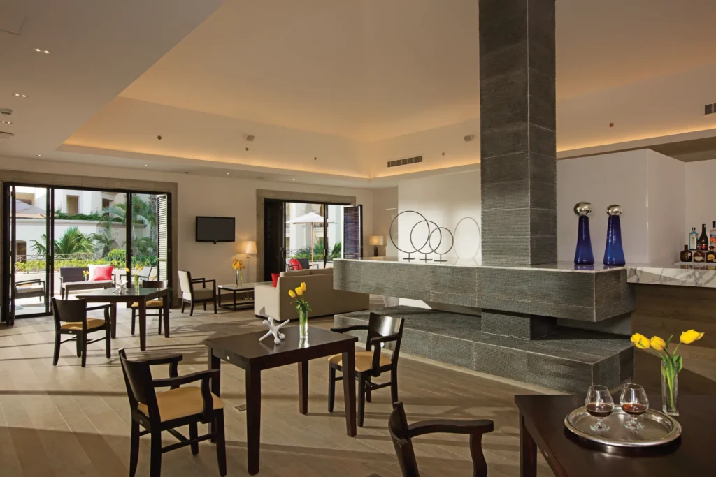 Modern Preferred Club lounge with seating areas and terrace access at Dreams Los Cabos Suites Golf Resort & Spa.