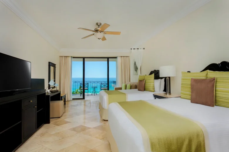 Preferred Club One Bedroom Suite Ocean View bedroom with two double beds and balcony overlooking the ocean at Dreams Los Cabos.