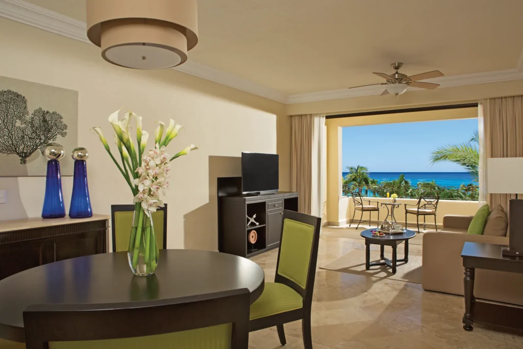 Preferred Club One Bedroom Suite Ocean View living room with dining area and balcony overlooking the Sea of Cortez at Dreams Los Cabos.