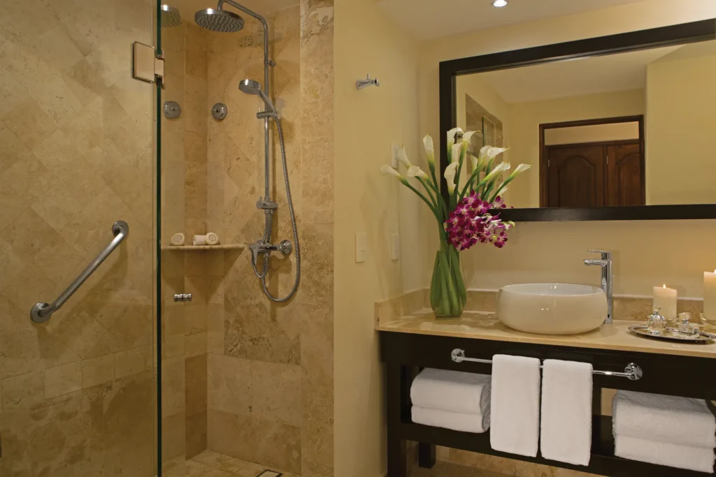 Marble bathroom with glass rain shower and vanity sink in the Preferred Club Presidential Suite at Dreams Los Cabos.