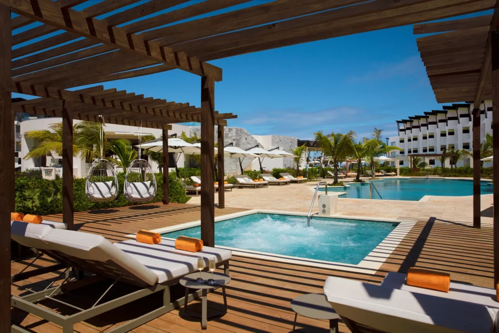 Overhead aerial view of the tropical resort pool at Dreams Macao Beach Punta Cana with palm islands and loungers.
