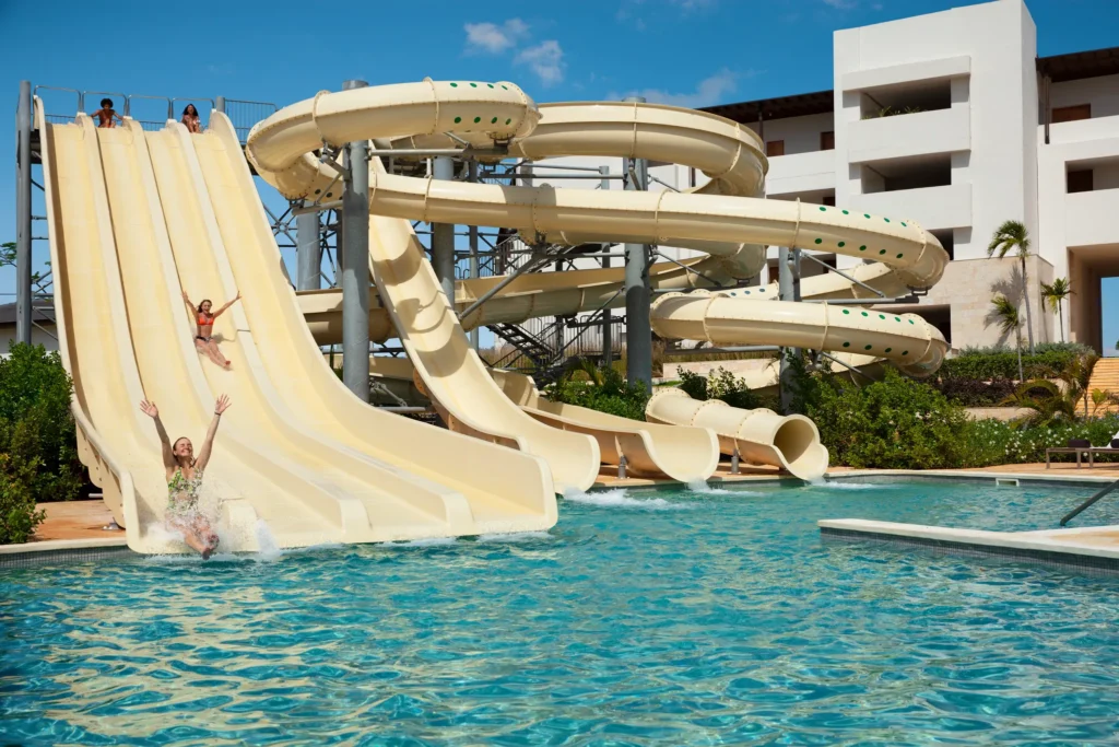 Guests enjoying thrilling water slides at the water park at Dreams Macao Beach Punta Cana Resort.