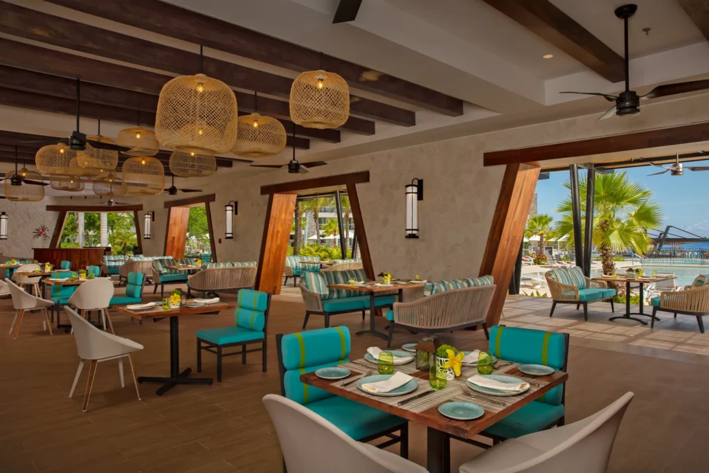 Bluewater Grill steakhouse at Dreams Natura Resort & Spa featuring elegant poolside dining, premium grilled steaks, and refined ambiance.