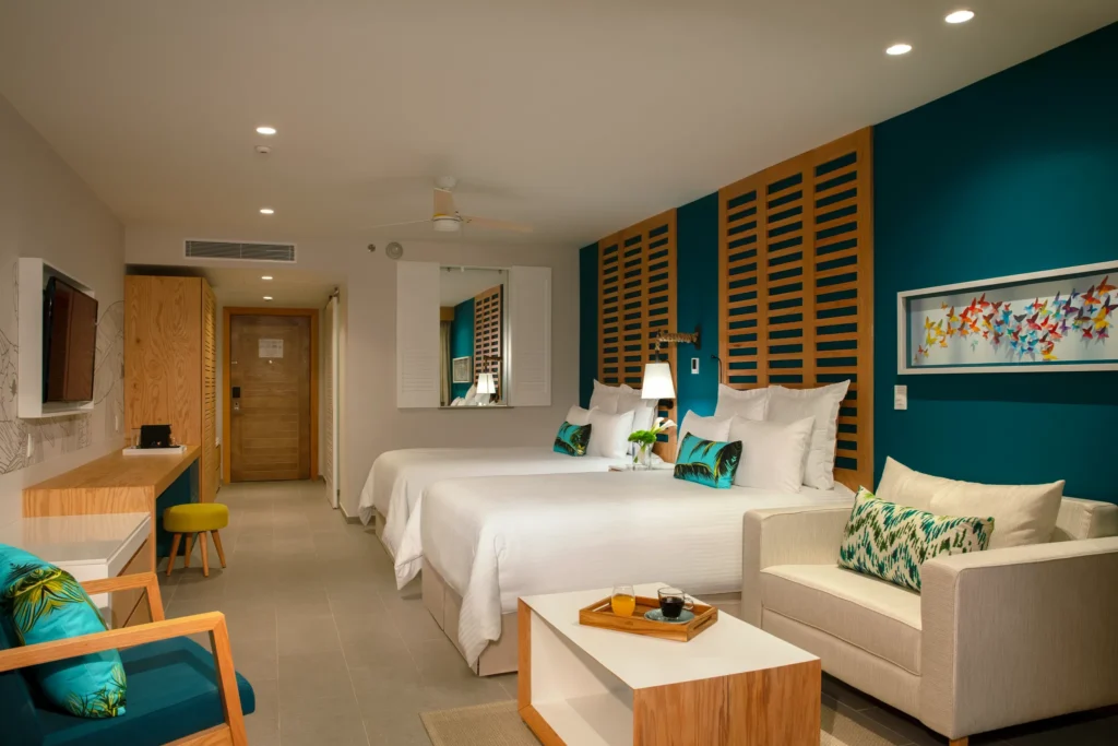 Family Junior Suite Ocean View with two double beds, sofa, and modern décor at Dreams Natura Resort & Spa.