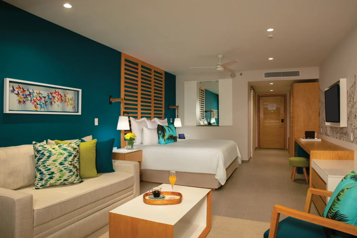 Junior Suite Ocean View with king bed and balcony overlooking the ocean at Dreams Natura Resort & Spa.