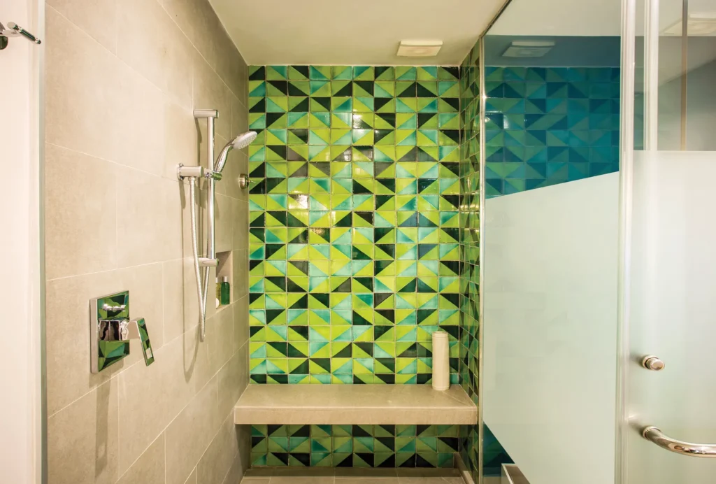 Junior Suite Partial Ocean View walk-in shower with green mosaic tile wall at Dreams Natura Resort & Spa.
