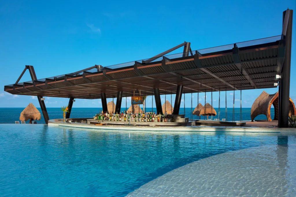 Manatees swim-up bar at Dreams Natura Resort & Spa featuring a lively pool setting, refreshing cocktails, and a relaxed beach-casual atmosphere.