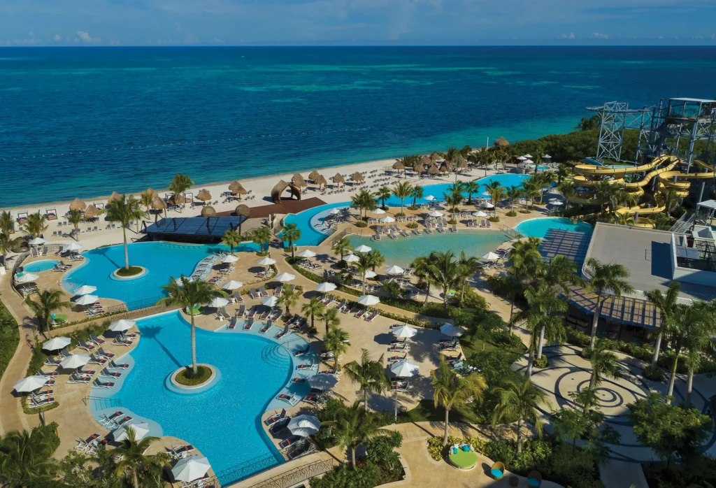 Aerial view of expansive pools and beachfront at Dreams Natura Resort & Spa in Riviera Cancun.