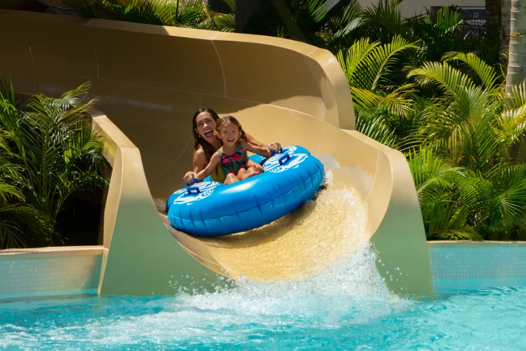 Mother and daughter enjoying a water slide splash at Dreams Natura Resort & Spa family water park.