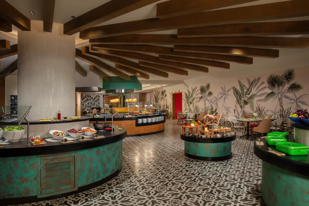 World Café international buffet at Dreams Natura Resort & Spa featuring diverse global cuisine stations and a casual dining atmosphere.
