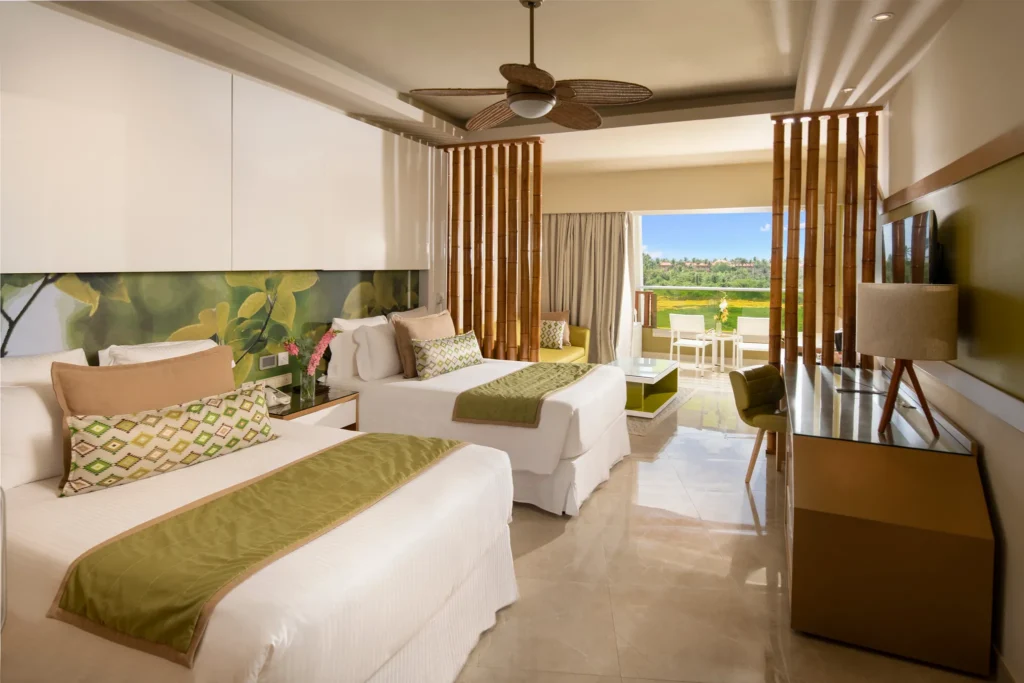 Preferred Club Junior Suite Partial Ocean View with two double beds and balcony at Dreams Onyx Resort & Spa.