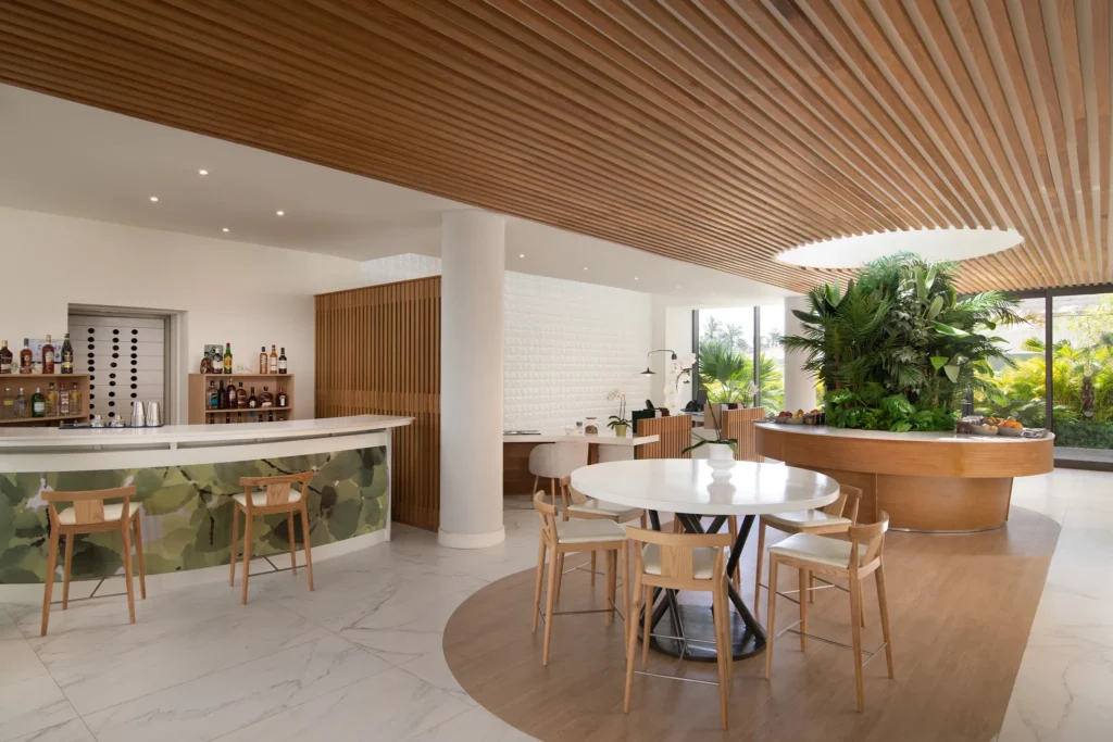 Bright lounge with bar, seating, and greenery in family section at Dreams Onyx Resort & Spa.