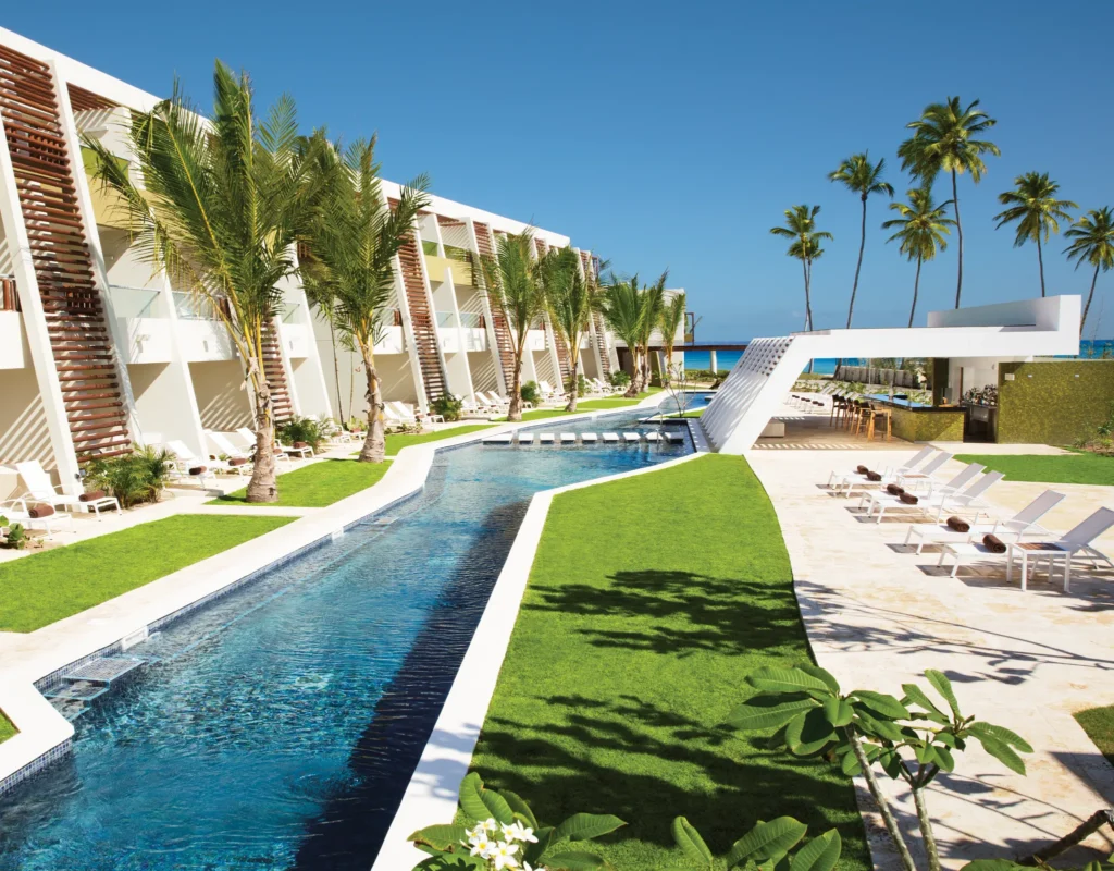 Family-friendly pool with lounge chairs and tropical landscaping at Dreams Onyx Resort & Spa.